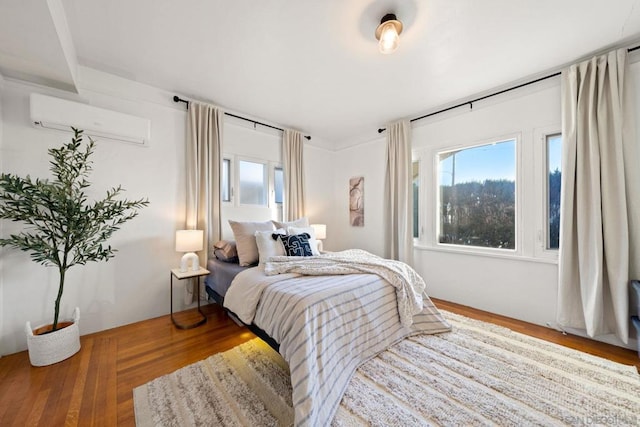 bedroom featuring wood-type flooring and a wall mounted AC