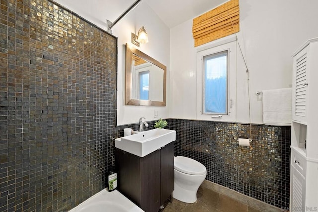 bathroom featuring tile patterned floors, tile walls, toilet, and vanity