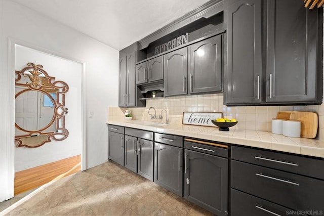 kitchen with backsplash, sink, and tile countertops