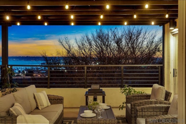 balcony at dusk featuring an outdoor living space