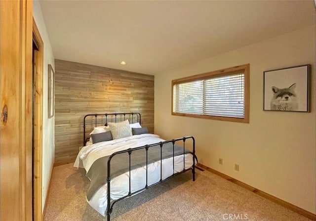 carpeted bedroom featuring wood walls