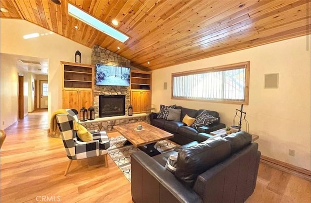 living room featuring vaulted ceiling with skylight, a fireplace, light hardwood / wood-style flooring, built in features, and wood ceiling