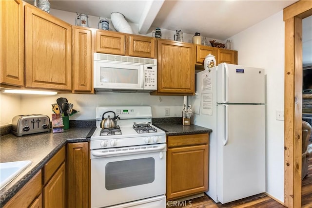 kitchen with wood-type flooring, sink, and white appliances