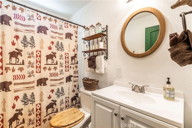 bathroom with curtained shower, toilet, and vanity