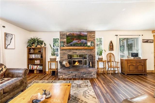 living room featuring dark hardwood / wood-style flooring and a stone fireplace