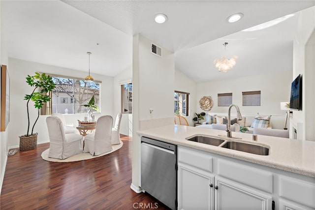 kitchen featuring white cabinetry, lofted ceiling, dishwasher, hanging light fixtures, and sink