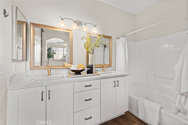 bathroom with ceiling fan, hardwood / wood-style flooring, vanity, and shower / bathtub combination with curtain