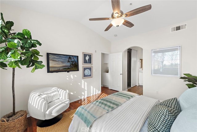 bedroom with ceiling fan, vaulted ceiling, dark hardwood / wood-style floors, and ensuite bathroom