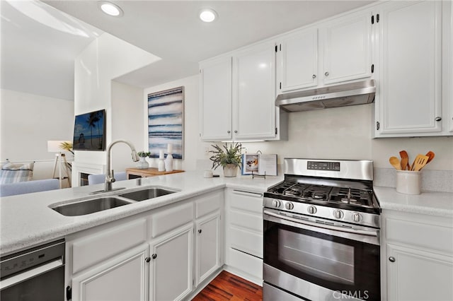 kitchen with dishwasher, stainless steel gas range oven, sink, white cabinetry, and dark wood-type flooring