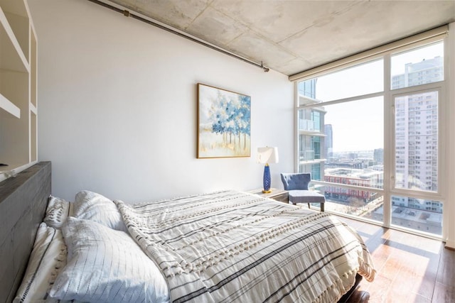 bedroom featuring floor to ceiling windows and wood-type flooring