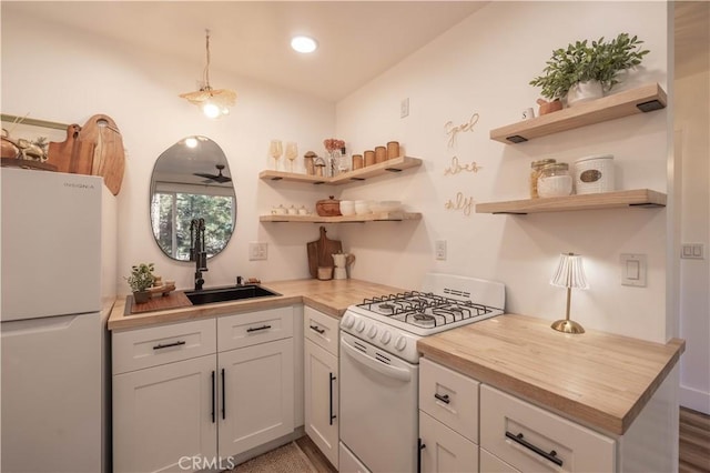 kitchen with ceiling fan, white cabinets, wooden counters, and white appliances