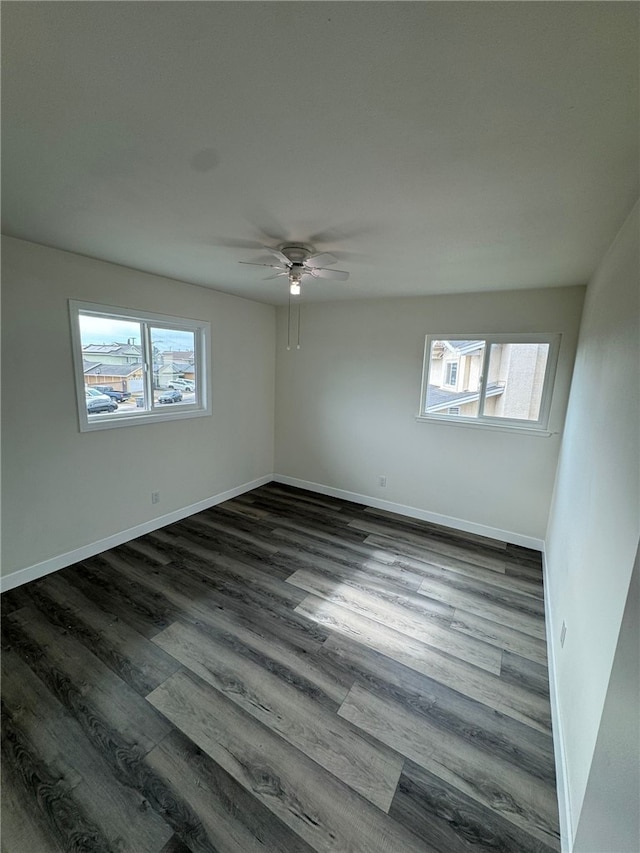 empty room with ceiling fan and dark hardwood / wood-style flooring