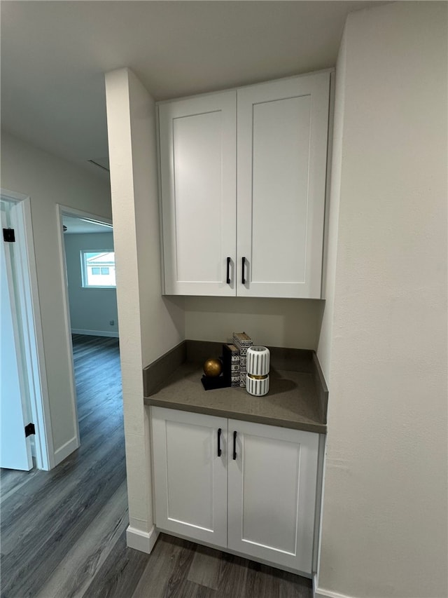 bar featuring white cabinets and dark wood-type flooring