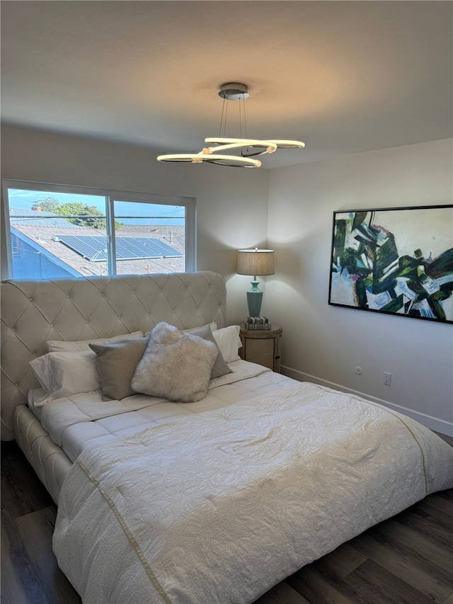 bedroom with a chandelier and dark hardwood / wood-style floors