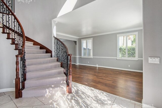 entryway featuring light tile patterned flooring and crown molding