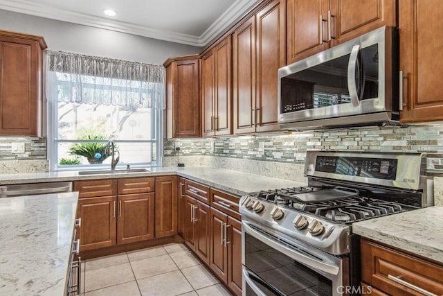 kitchen with sink, crown molding, light stone counters, and stainless steel appliances