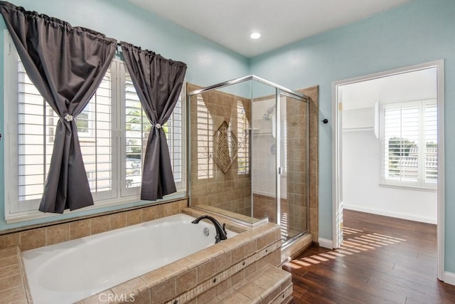 bathroom featuring shower with separate bathtub, hardwood / wood-style floors, and a healthy amount of sunlight