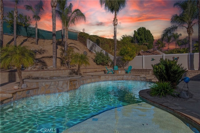 pool at dusk with pool water feature