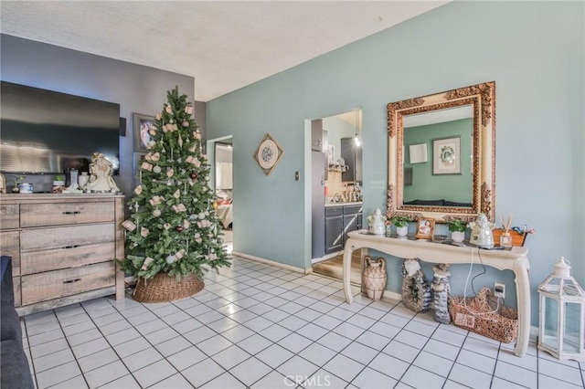 interior space featuring light tile patterned flooring and baseboards