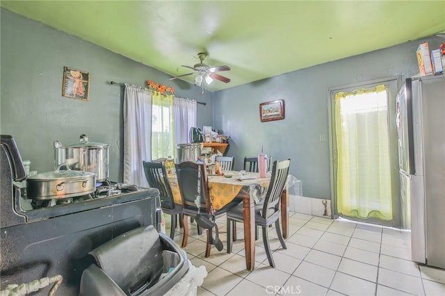 dining area with a ceiling fan and light tile patterned flooring