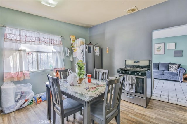 dining room featuring wood finished floors and visible vents