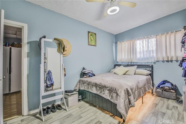 bedroom featuring a textured ceiling, wood finished floors, and a ceiling fan