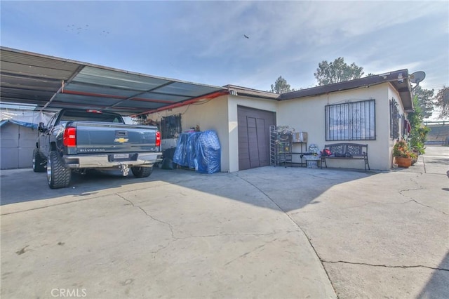 view of front of house featuring a carport, concrete driveway, and stucco siding