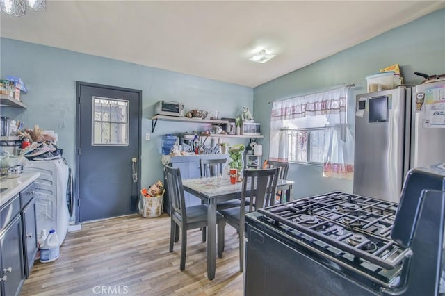 kitchen with freestanding refrigerator, light countertops, light wood-style flooring, and open shelves