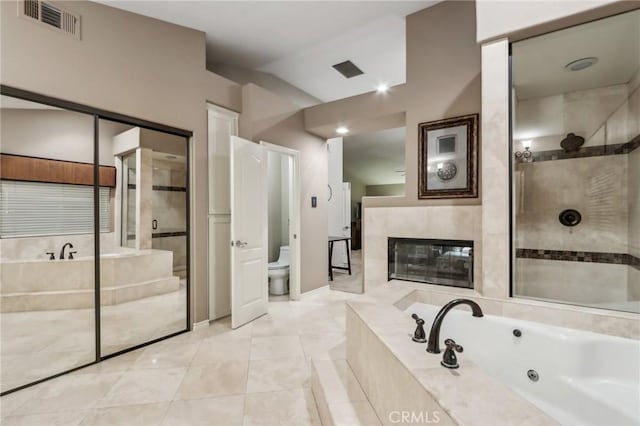 bathroom featuring toilet, visible vents, baseboards, a jetted tub, and a tile shower