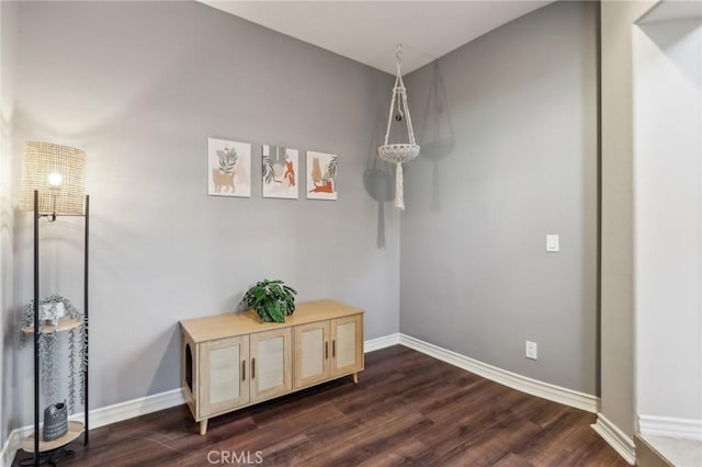 dining space featuring dark wood-type flooring and baseboards