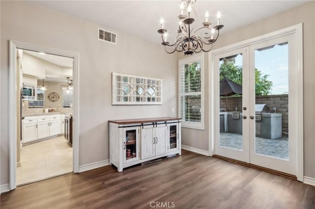 doorway to outside with baseboards, visible vents, dark wood-style flooring, and french doors