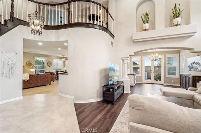 entryway with baseboards, wood finished floors, and ceiling fan with notable chandelier