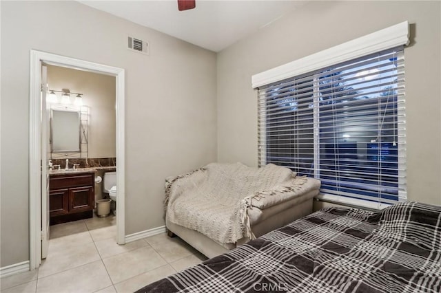 tiled bedroom featuring sink, ceiling fan, and ensuite bathroom