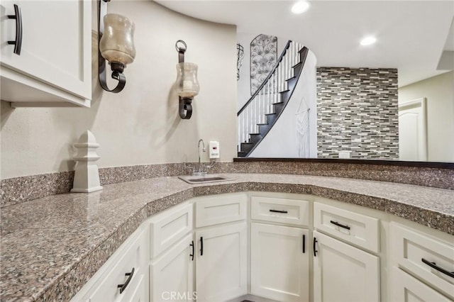 kitchen featuring white cabinets, a sink, and recessed lighting