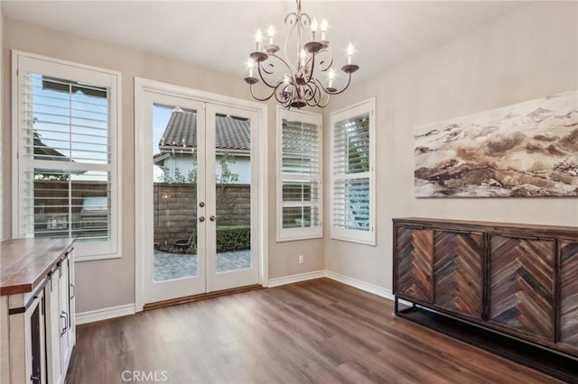 doorway to outside with a notable chandelier, french doors, dark wood finished floors, and baseboards