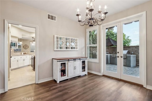 doorway featuring french doors, wood finished floors, visible vents, and baseboards