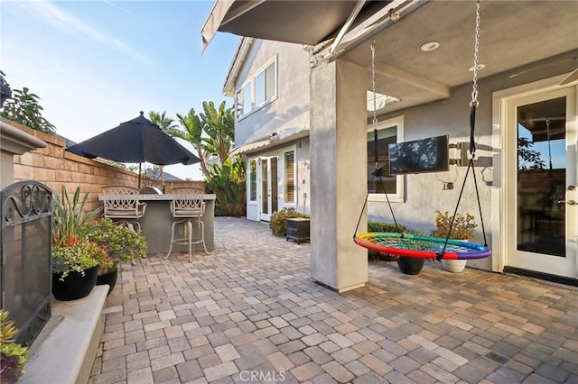 view of patio featuring fence and outdoor dry bar