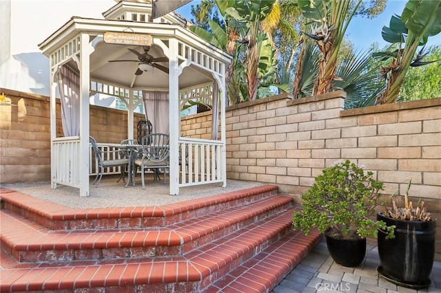 exterior space with outdoor dining area, a fenced backyard, ceiling fan, and a gazebo