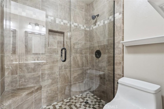 bathroom with a shower with shower door and toilet