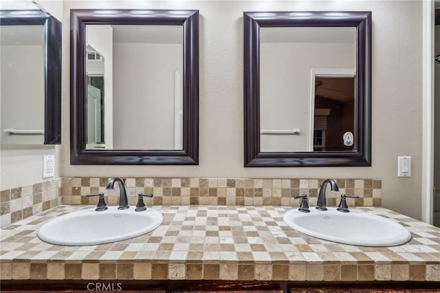 bathroom featuring double vanity, a sink, and decorative backsplash