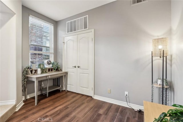 interior space featuring baseboards, visible vents, and dark wood-style flooring