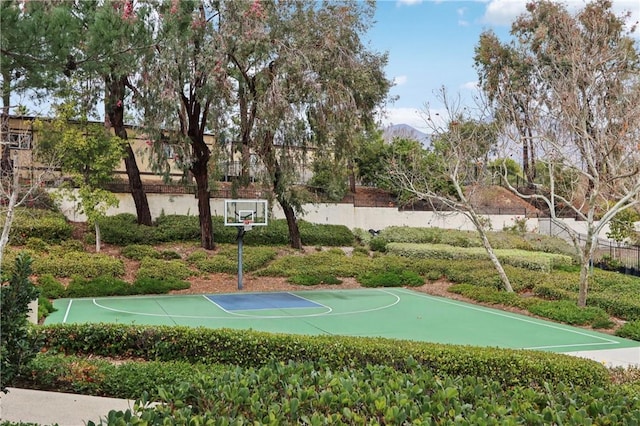 view of sport court featuring community basketball court, fence, and a mountain view