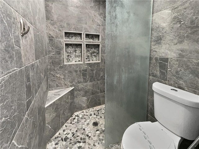 bathroom featuring toilet and a tile shower