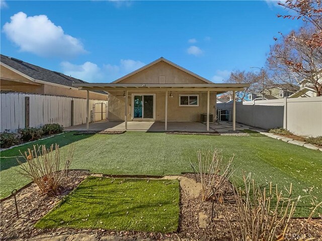 rear view of house featuring central AC unit, a yard, and a patio