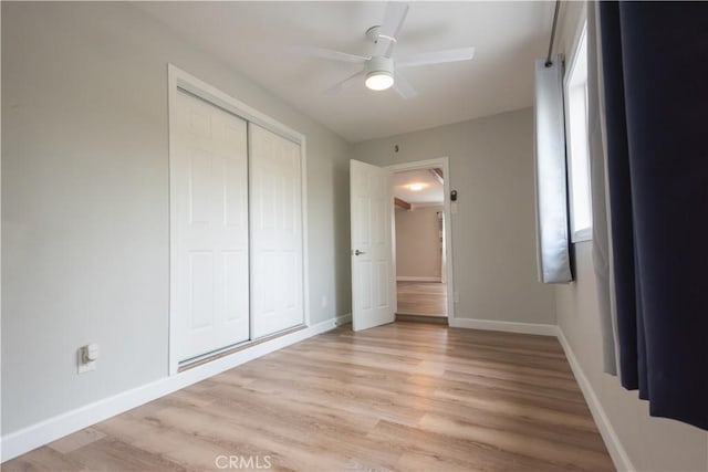 unfurnished bedroom with ceiling fan, a closet, and light hardwood / wood-style flooring