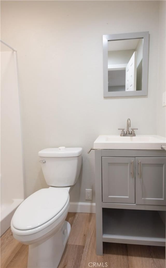 bathroom featuring a shower, wood-type flooring, toilet, and vanity