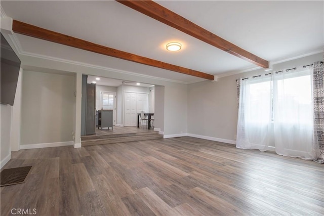 unfurnished living room featuring hardwood / wood-style floors, crown molding, and a wealth of natural light