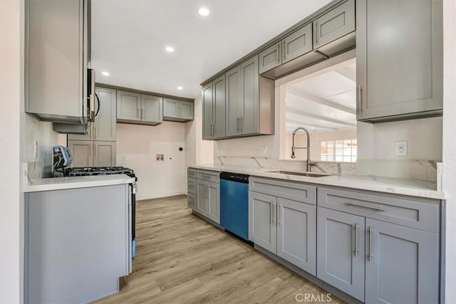 kitchen with dishwasher, sink, light wood-type flooring, gray cabinetry, and white gas range