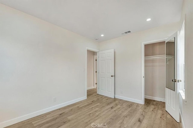 unfurnished bedroom with a closet and light hardwood / wood-style flooring