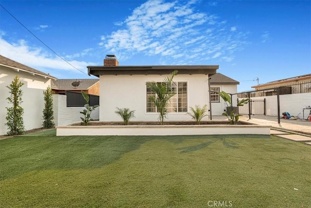 rear view of house featuring a yard